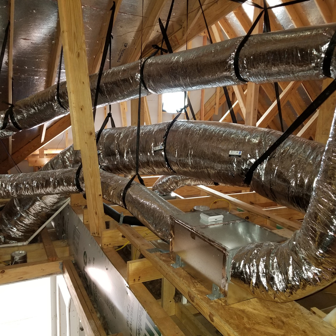 A bunch of duct work is hanging in the ceiling