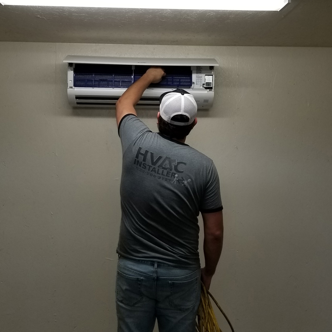 A man is working on an air conditioner.